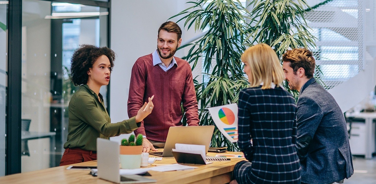 team of four dental website experts discussing strategy around a table